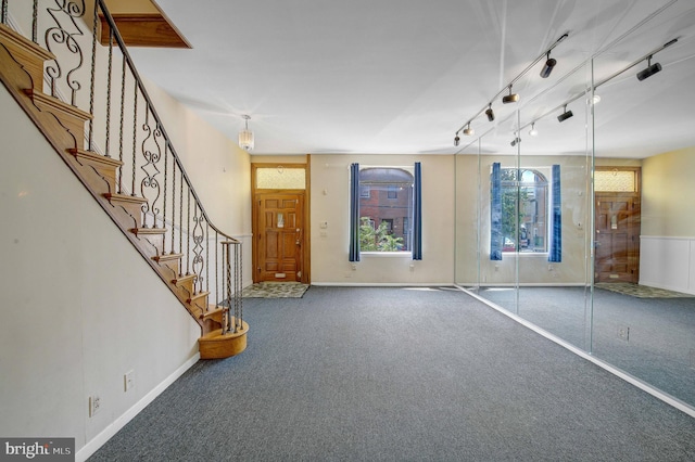 foyer entrance featuring dark carpet and rail lighting