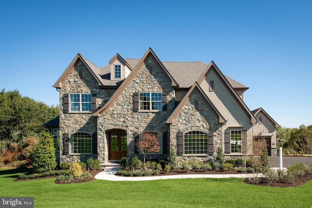 view of front of home with french doors and a front lawn