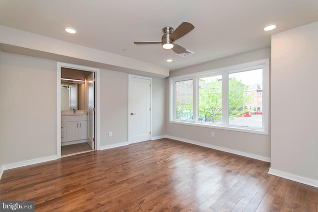 unfurnished bedroom with connected bathroom, ceiling fan, and dark hardwood / wood-style floors