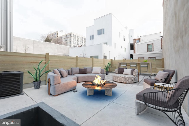 view of terrace with central AC and an outdoor living space with a fire pit