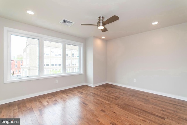 empty room with dark wood-type flooring and ceiling fan