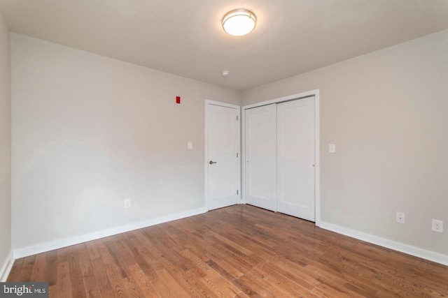 unfurnished bedroom featuring dark hardwood / wood-style flooring and a closet