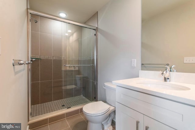 bathroom featuring vanity, tile floors, a shower with door, and toilet