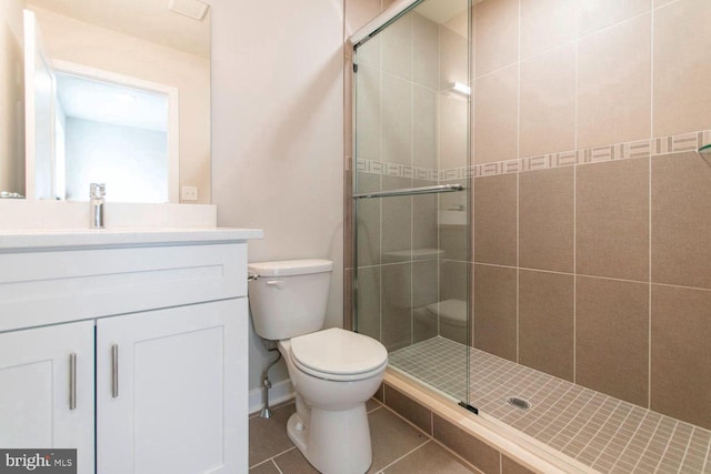 bathroom with an enclosed shower, vanity, tile flooring, and toilet