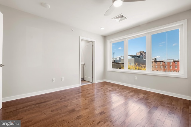 empty room with ceiling fan and dark wood-type flooring