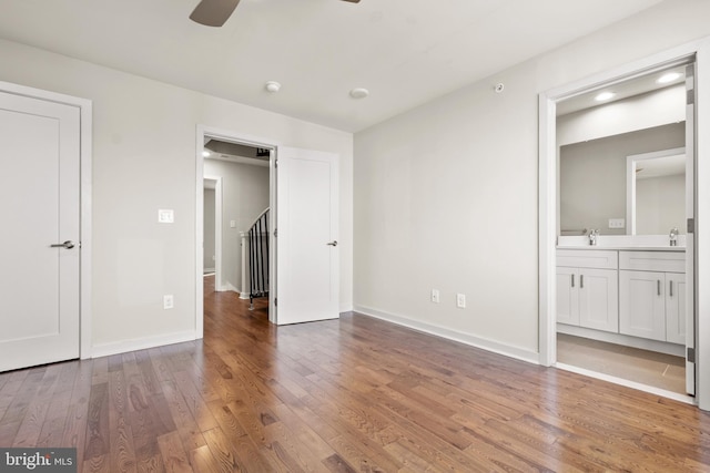 unfurnished bedroom with connected bathroom, sink, ceiling fan, and hardwood / wood-style flooring