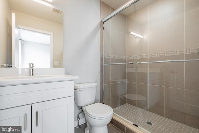 bathroom with toilet, vanity, and an enclosed shower