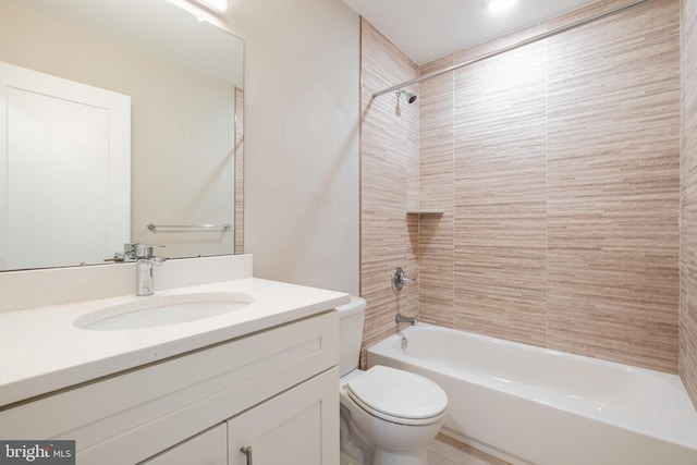 full bathroom featuring tiled shower / bath combo, vanity, and toilet