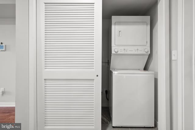 washroom with stacked washer and dryer and wood-type flooring