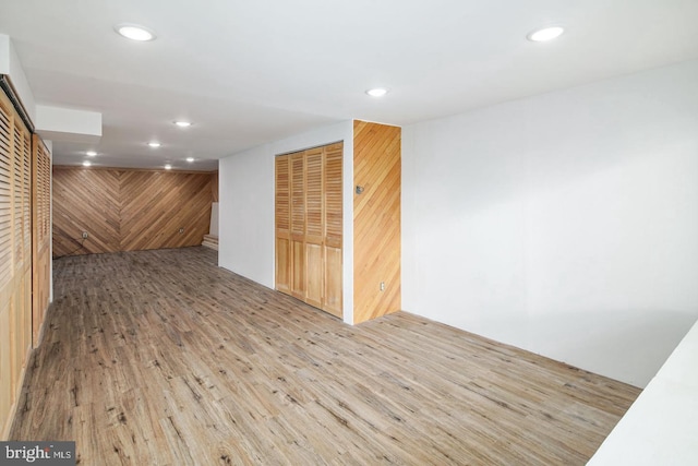 interior space with wood walls and light wood-type flooring