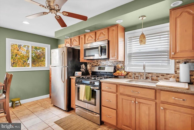 kitchen with decorative light fixtures, tasteful backsplash, stainless steel appliances, ceiling fan, and sink