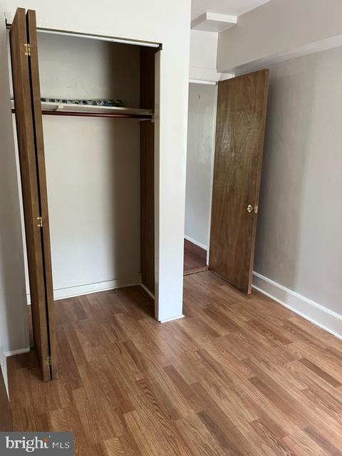 unfurnished bedroom featuring hardwood / wood-style floors and a closet