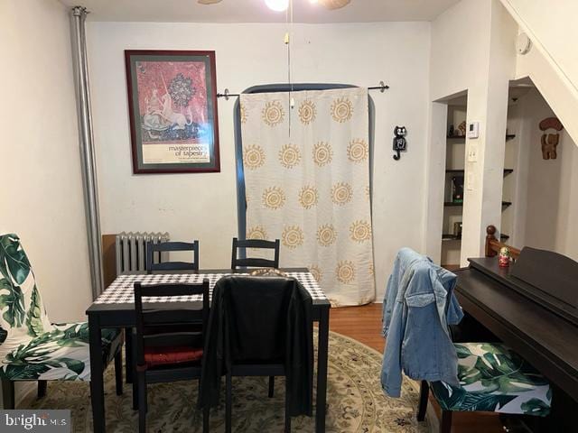 dining area featuring hardwood / wood-style floors and radiator heating unit