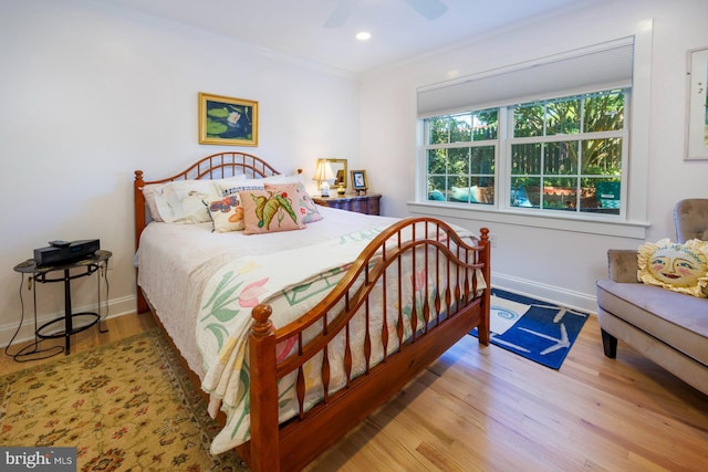 bedroom with ceiling fan, ornamental molding, and light hardwood / wood-style floors