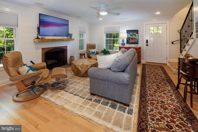 living room with light hardwood / wood-style flooring, a fireplace, and a healthy amount of sunlight