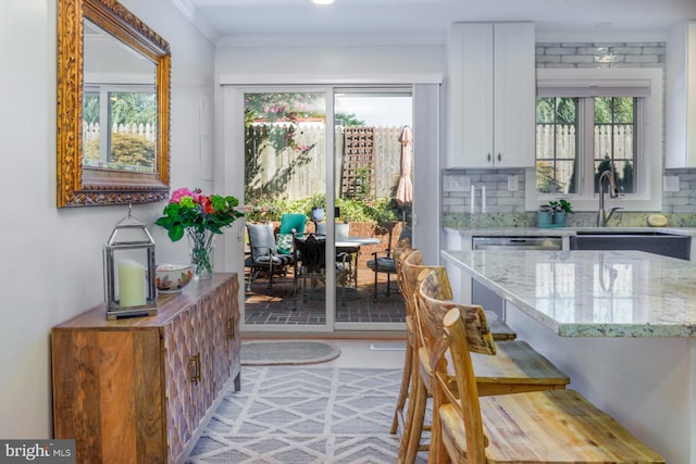 dining room with ornamental molding, sink, and a wealth of natural light