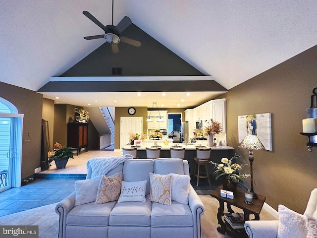 living room with high vaulted ceiling, ceiling fan, and light tile floors