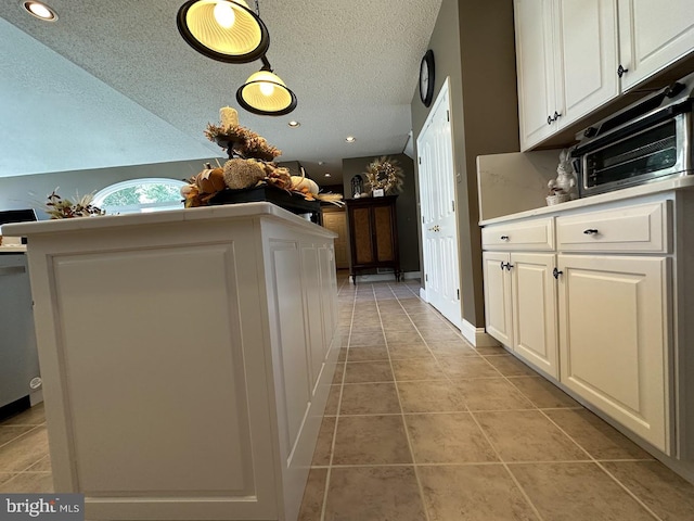 kitchen with light tile floors, white cabinetry, and a textured ceiling