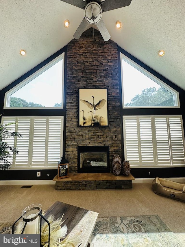 carpeted living room with high vaulted ceiling, ceiling fan, a textured ceiling, and a fireplace