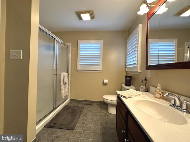 bathroom featuring vanity, tile flooring, a shower with door, and toilet