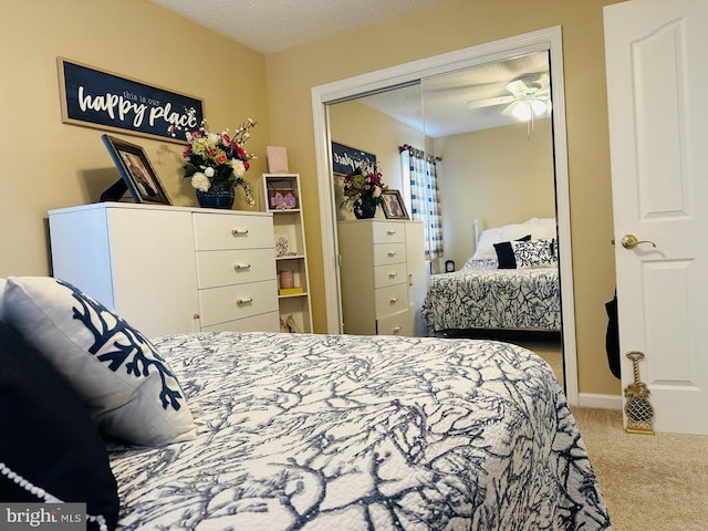 carpeted bedroom with ceiling fan, a closet, and a textured ceiling