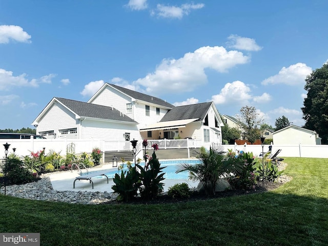 back of property with a lawn, a patio area, and a fenced in pool