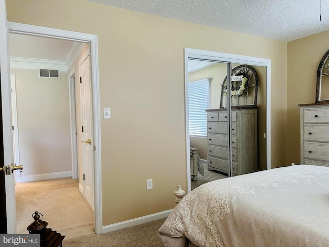 bedroom featuring a closet, a textured ceiling, and light colored carpet