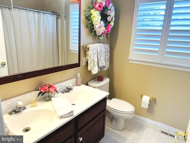 bathroom with toilet, tile flooring, and vanity