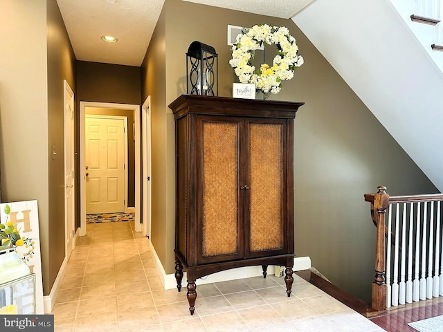 hallway featuring light tile floors