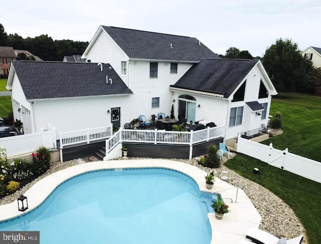 view of pool with a wooden deck and a yard