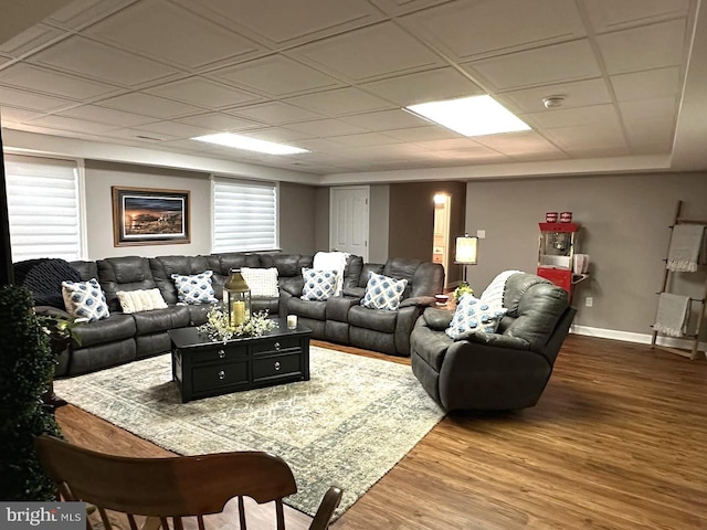 living room featuring a paneled ceiling and hardwood / wood-style flooring