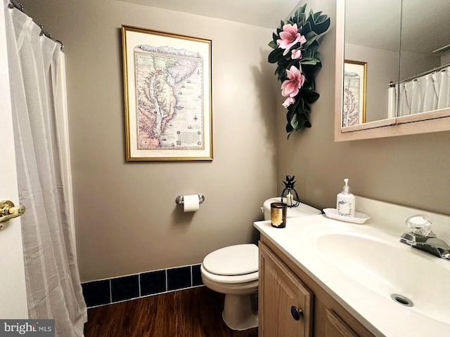 bathroom with oversized vanity, toilet, and wood-type flooring