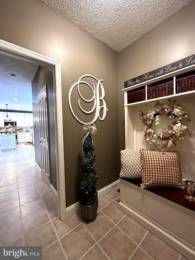 mudroom featuring light tile floors and a textured ceiling