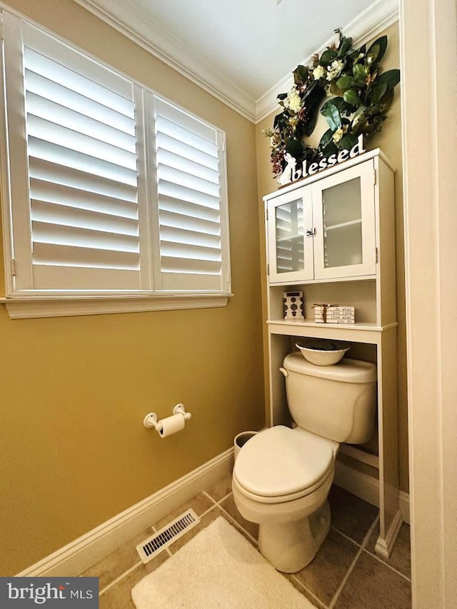 bathroom with tile floors, toilet, and ornamental molding