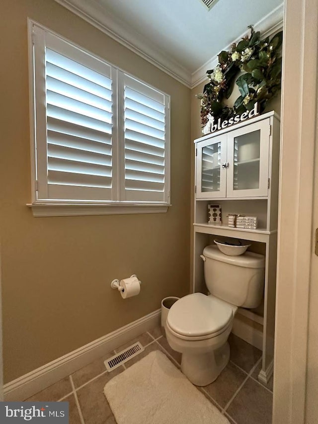 bathroom featuring toilet, ornamental molding, and tile floors