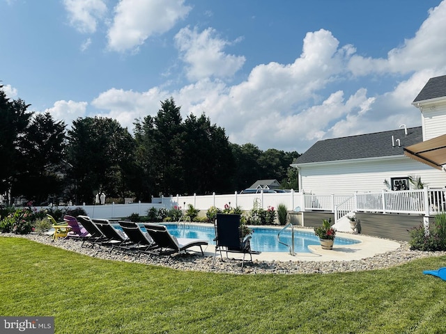 view of pool with a wooden deck and a lawn