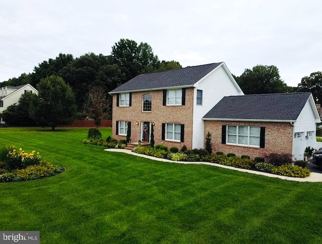 colonial-style house featuring a front lawn and a garage