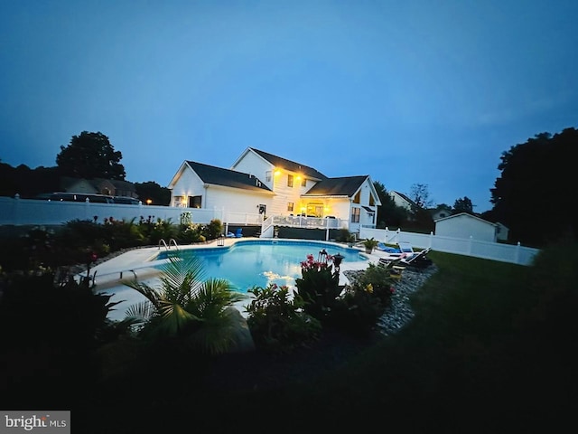 view of pool at twilight