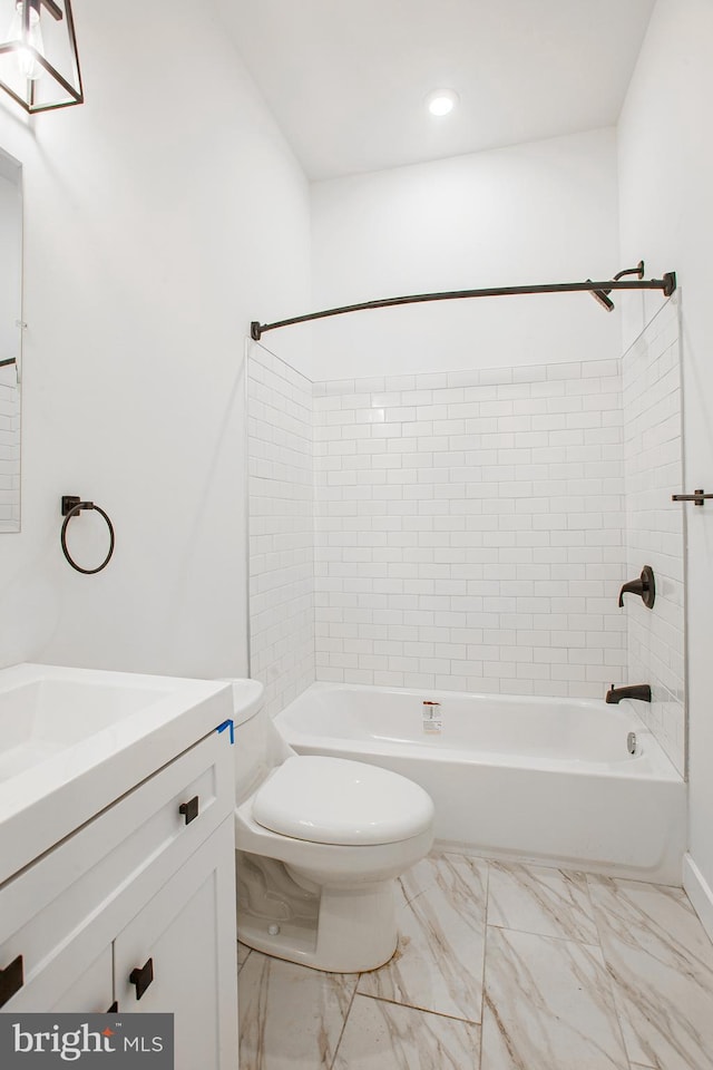 full bathroom with vanity, tiled shower / bath combo, and toilet