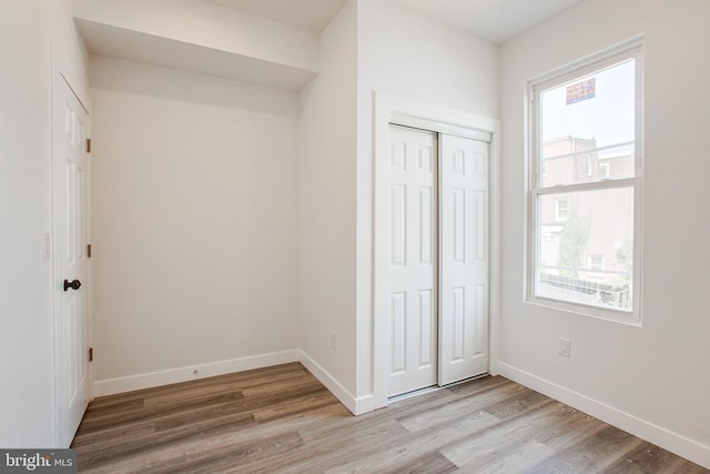 unfurnished bedroom featuring a closet and light wood-type flooring