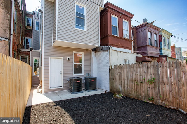 rear view of house with central air condition unit and a patio area