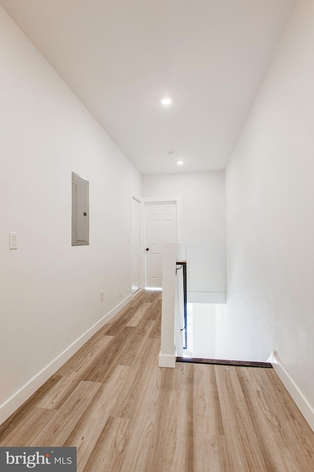 laundry room with electric panel and light hardwood / wood-style floors