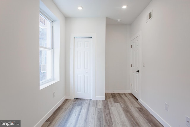 unfurnished bedroom with light wood-type flooring and a closet