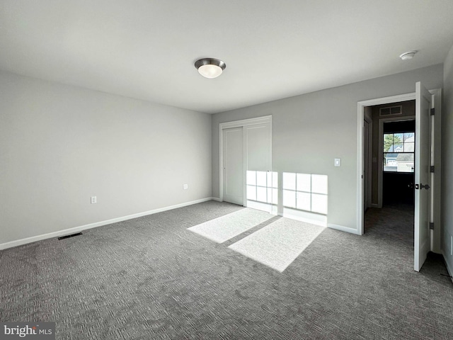 unfurnished bedroom with dark carpet