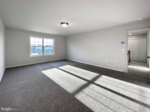 unfurnished room featuring dark colored carpet