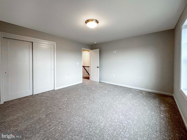 unfurnished bedroom featuring carpet and a closet