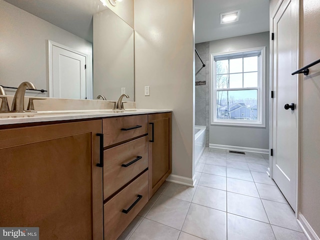 bathroom with tile patterned floors, vanity, and tiled shower / bath combo