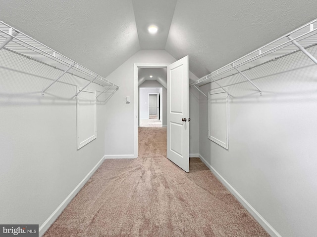 spacious closet featuring carpet flooring and vaulted ceiling