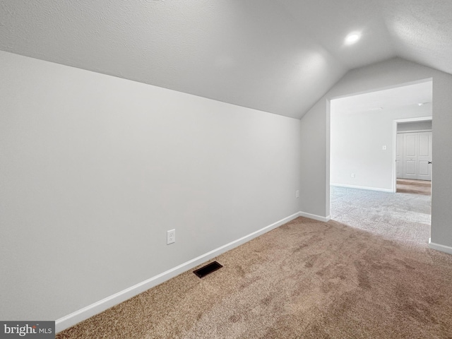 bonus room featuring carpet flooring, a textured ceiling, and lofted ceiling