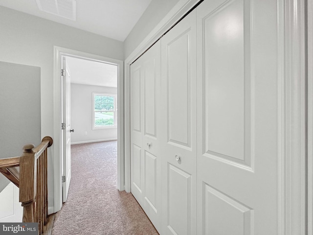 corridor featuring light colored carpet